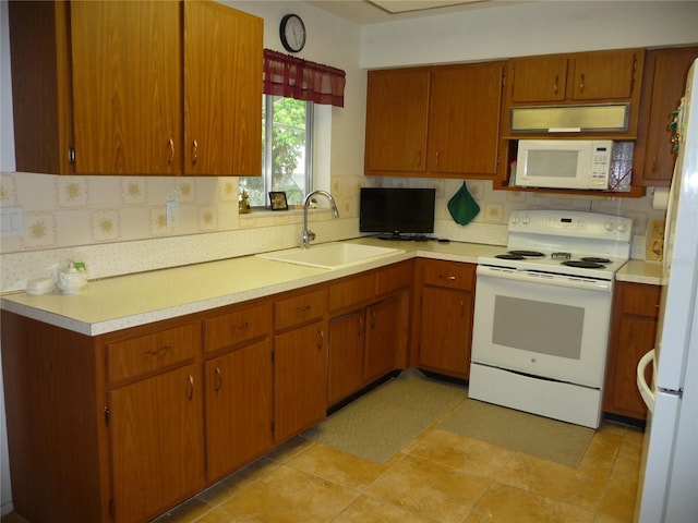 kitchen with backsplash, sink, light tile patterned floors, and white appliances