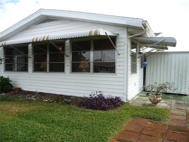 view of side of home with a yard