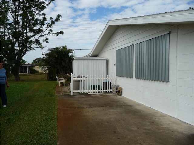 view of property exterior with a lawn and a patio area