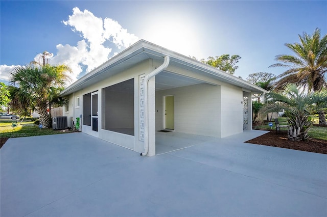 view of side of home featuring cooling unit and a patio