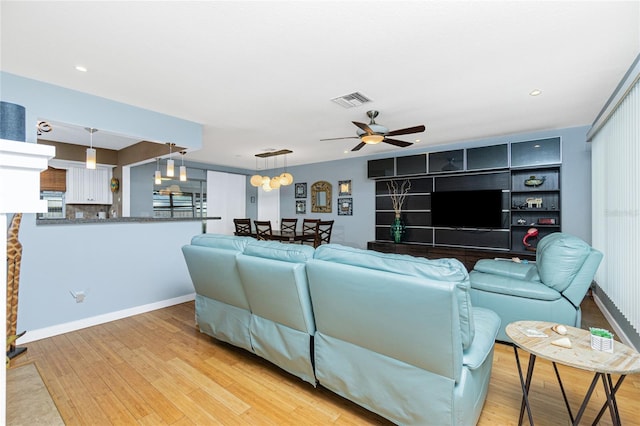 living room featuring light hardwood / wood-style floors and ceiling fan