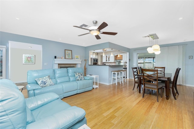 living room featuring light wood-type flooring and ceiling fan