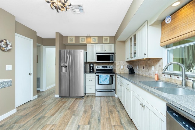 kitchen with white cabinets, hardwood / wood-style floors, stainless steel appliances, and sink