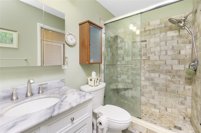 bathroom with walk in shower, vanity, and toilet