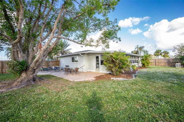 back of property with a lawn and a patio