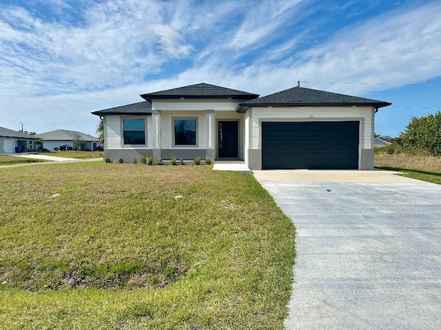 view of front of home with a front yard and a garage