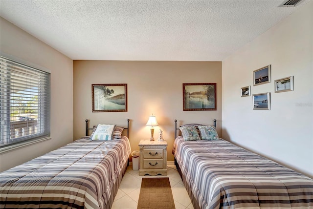 tiled bedroom with a textured ceiling