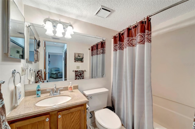 full bathroom featuring shower / bath combo with shower curtain, vanity, a textured ceiling, and toilet