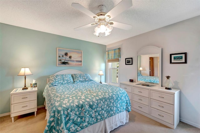 bedroom featuring light carpet, a textured ceiling, and ceiling fan