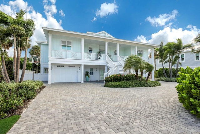 raised beach house with a porch and a garage