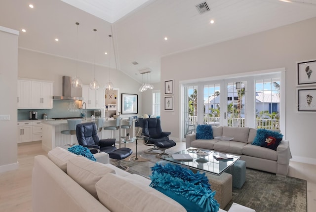 living room featuring high vaulted ceiling and an inviting chandelier