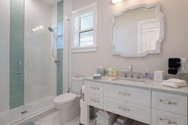 bathroom featuring toilet, vanity, and a shower with shower door