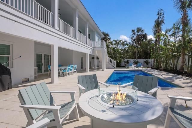 view of swimming pool featuring an outdoor fire pit and a patio