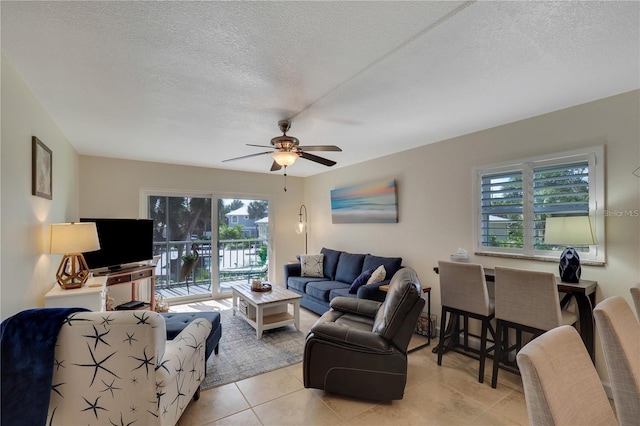 tiled living room with a healthy amount of sunlight, ceiling fan, and a textured ceiling