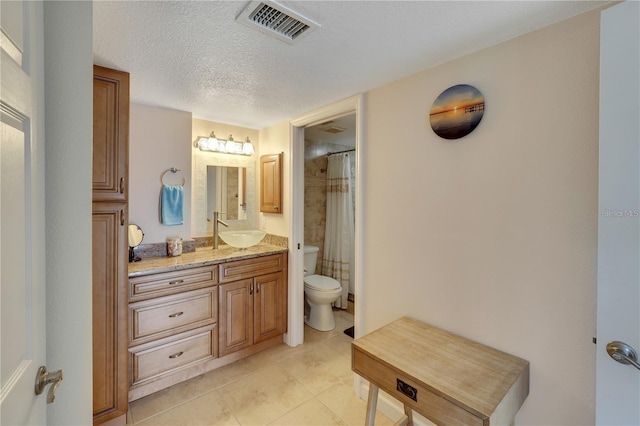 bathroom featuring toilet, a shower with shower curtain, vanity, tile patterned floors, and a textured ceiling