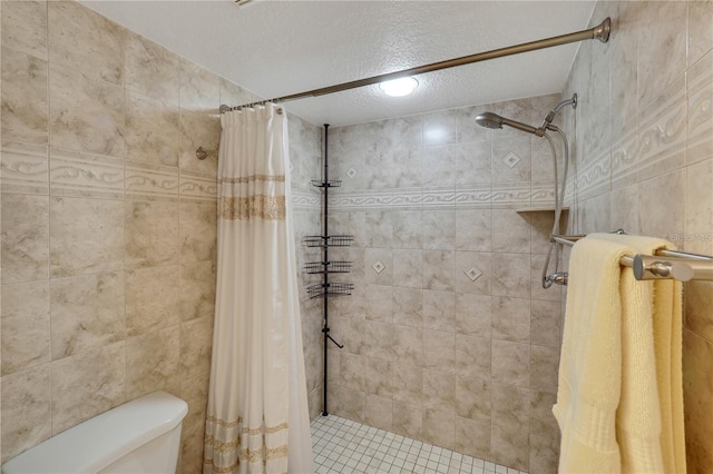 bathroom with toilet, a shower with shower curtain, and a textured ceiling