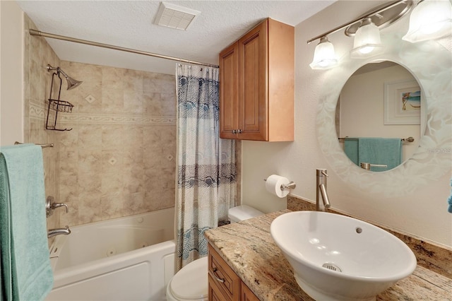 full bathroom featuring a textured ceiling, shower / bath combination with curtain, vanity, and toilet