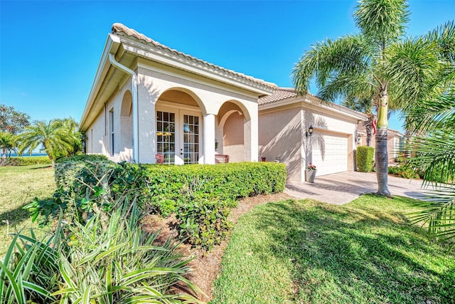 mediterranean / spanish-style house with a front yard and a garage