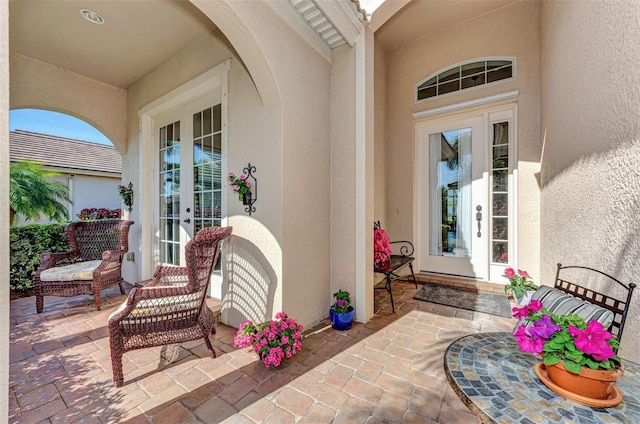 property entrance featuring a patio area and french doors