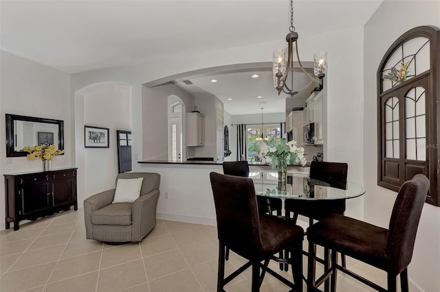 tiled dining space with an inviting chandelier