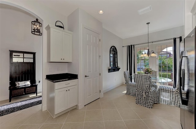 tiled dining area with a chandelier