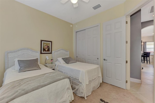 tiled bedroom featuring ceiling fan and a closet