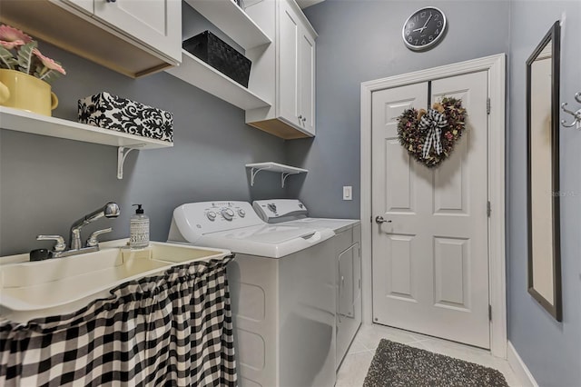 laundry area featuring cabinets, light tile patterned floors, sink, and washing machine and clothes dryer