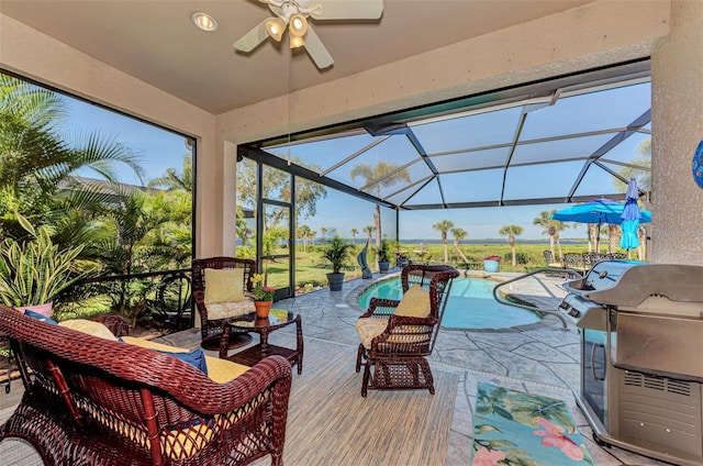 view of patio featuring glass enclosure, ceiling fan, and grilling area