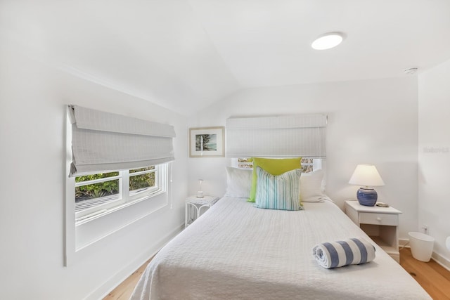 bedroom featuring light hardwood / wood-style flooring and vaulted ceiling