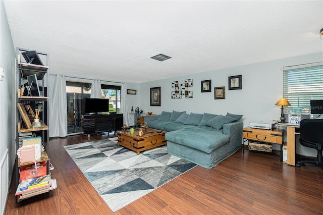 living room featuring a textured ceiling and dark hardwood / wood-style floors