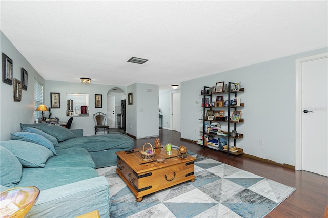 living room featuring a textured ceiling and dark hardwood / wood-style flooring