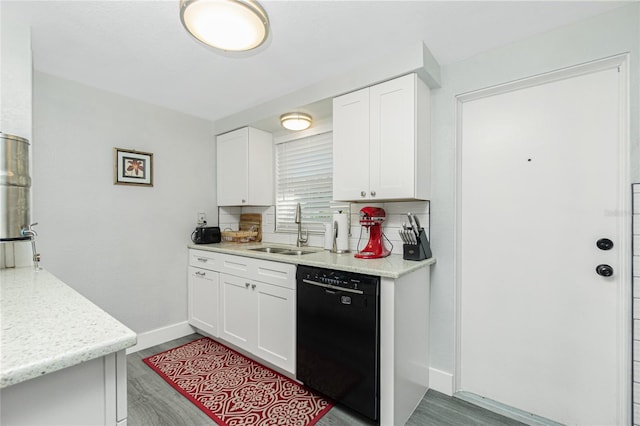 kitchen featuring sink, black dishwasher, white cabinetry, and tasteful backsplash