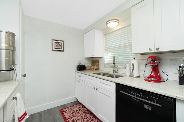 kitchen with sink, white cabinetry, light stone counters, black dishwasher, and backsplash