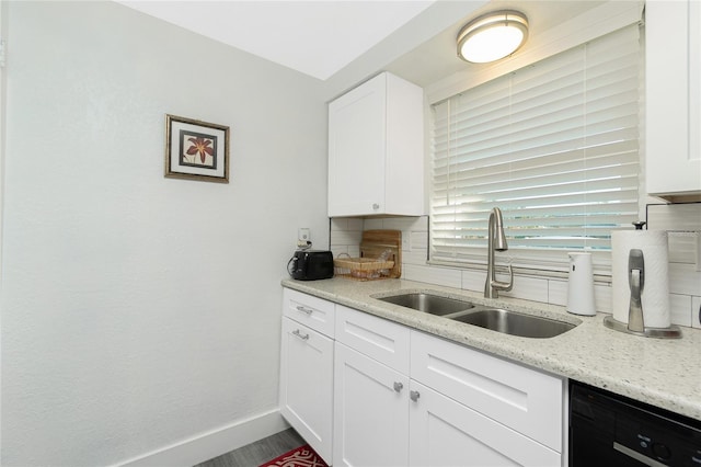 kitchen featuring sink, white cabinetry, dishwasher, backsplash, and light stone countertops