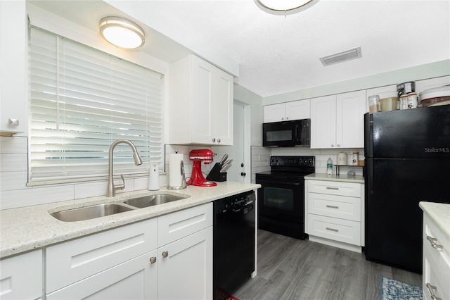 kitchen with sink, white cabinets, tasteful backsplash, dark hardwood / wood-style floors, and black appliances