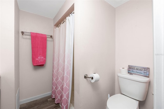 bathroom with toilet, hardwood / wood-style flooring, and walk in shower