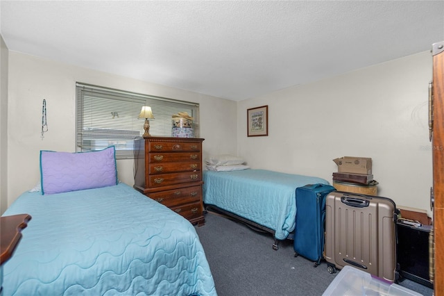 bedroom with a textured ceiling and dark colored carpet