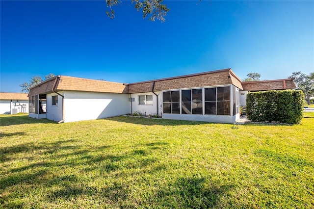 back of property with a yard and a sunroom