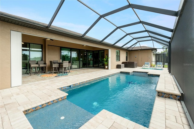 view of swimming pool with glass enclosure and a patio