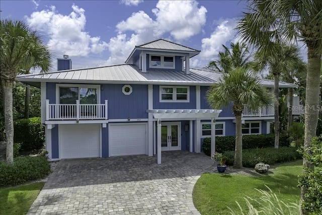 view of front of house with french doors, a balcony, and a garage