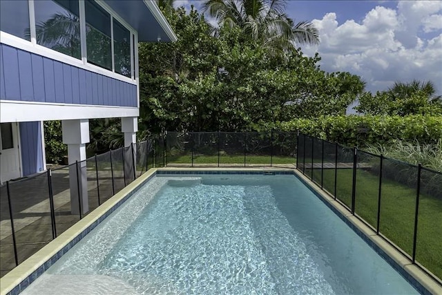 view of pool with a lawn