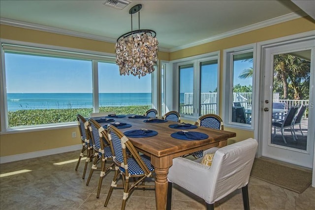 dining room featuring an inviting chandelier, crown molding, and a water view