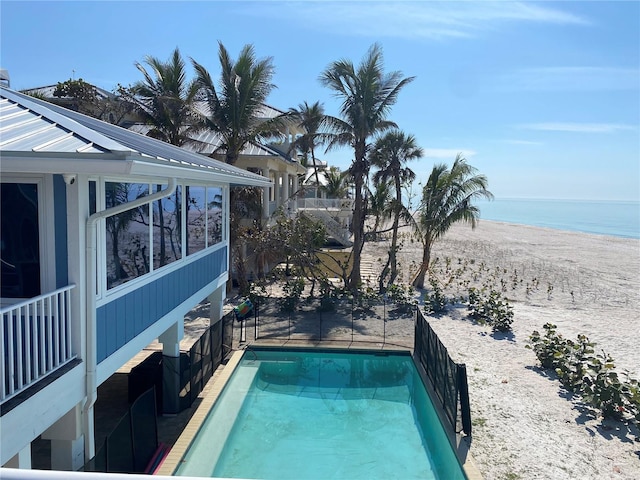 view of swimming pool with a water view and a view of the beach