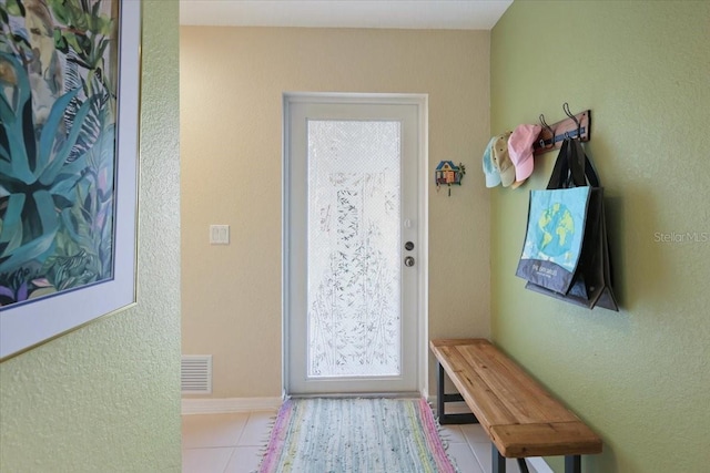 doorway to outside with light tile patterned flooring