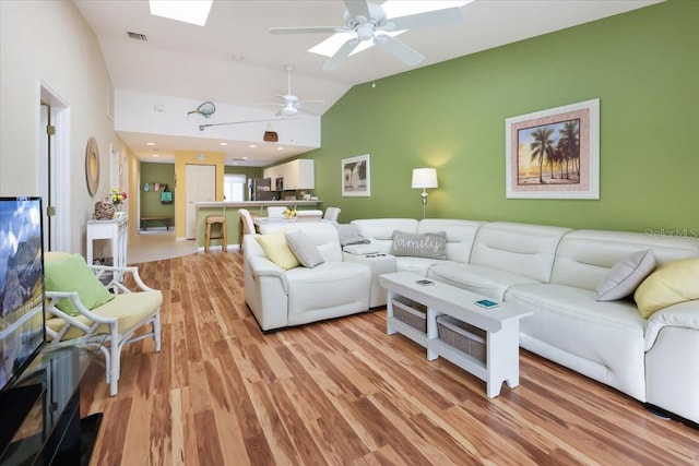 living room with light hardwood / wood-style floors and vaulted ceiling