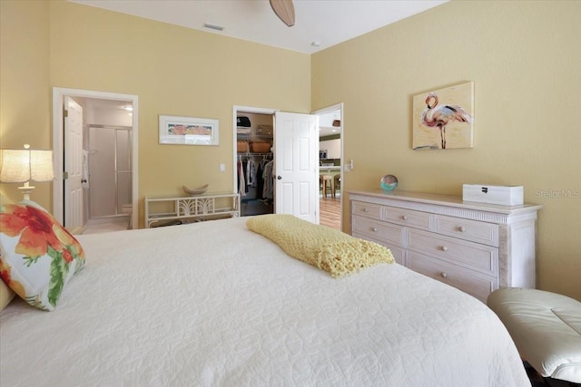 bedroom featuring ceiling fan, a walk in closet, a closet, and connected bathroom