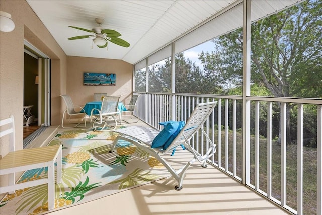 sunroom / solarium with ceiling fan and vaulted ceiling