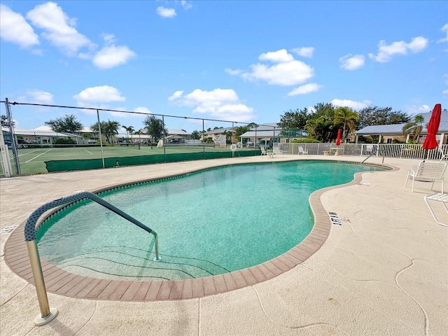 view of swimming pool featuring tennis court