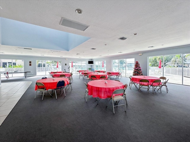 dining space featuring a textured ceiling and carpet