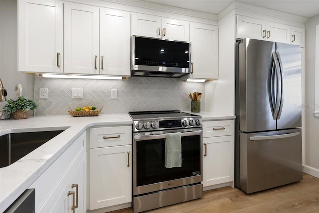 kitchen featuring light wood-type flooring, stainless steel appliances, and white cabinetry